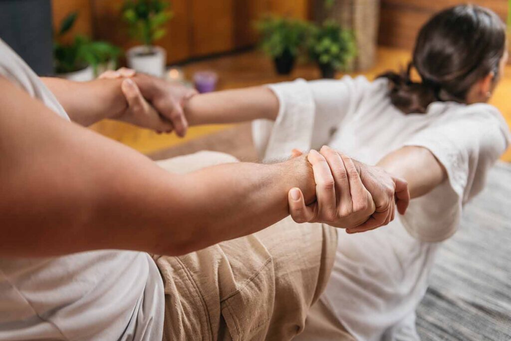 photo of intertwined hands engaged in thai bodywork