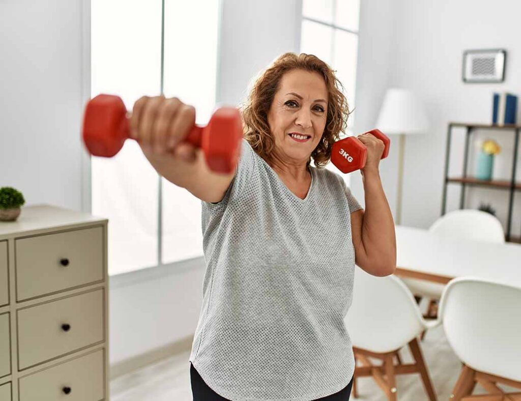photos of middle aged white woman in tshirt engaged in strength training with red dumbells in her home